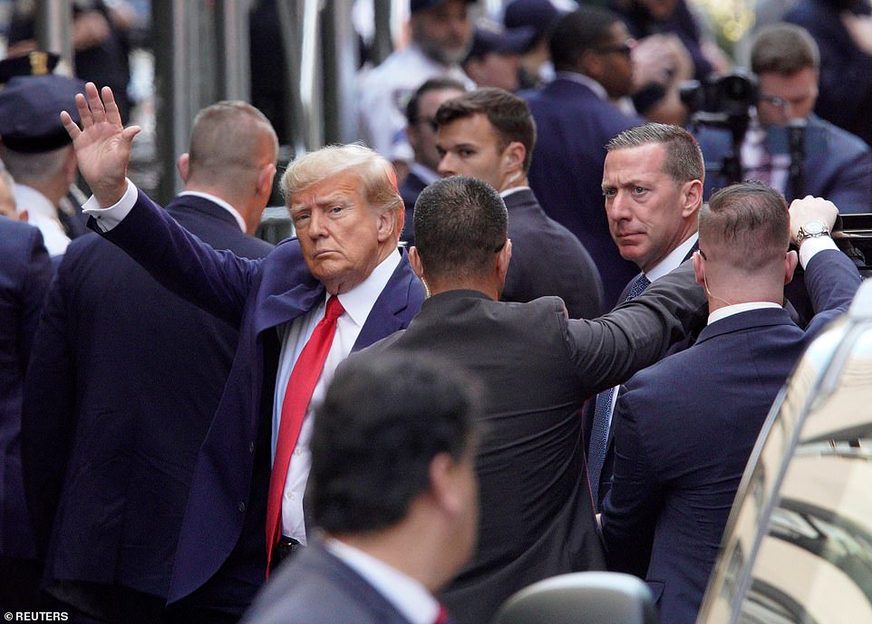 President Trump surrounded by Secret Service waves defiantly as he arrives at the Manhattan Court house for arraignment on Tuesday, April 4, 2023; New York.  Credit: REUTERS